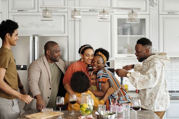 A family gathered and laughing together around a kitchen table